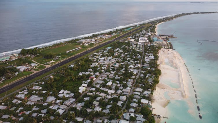 An aerial image of the airstrip alongside homes in the small, narrow country of Tuvalu.