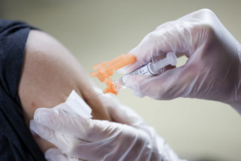A person administering a flu jab.