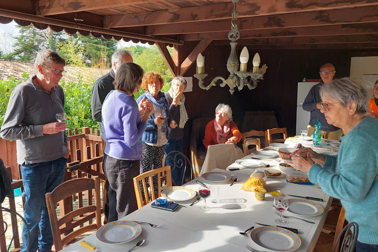 Des seniors autour d'une grande table.
