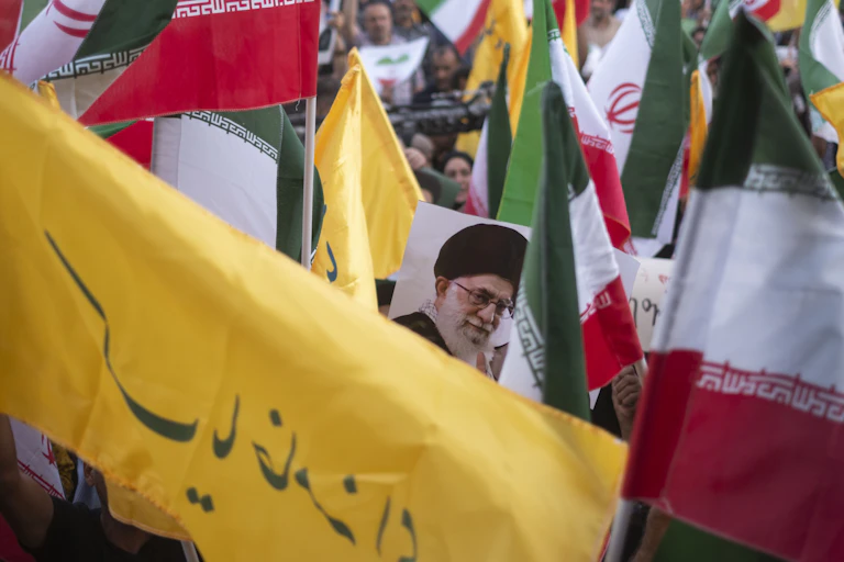 The picture of a man is seen between red, white and green flags.