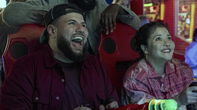 two people laugh out loud while looking up
