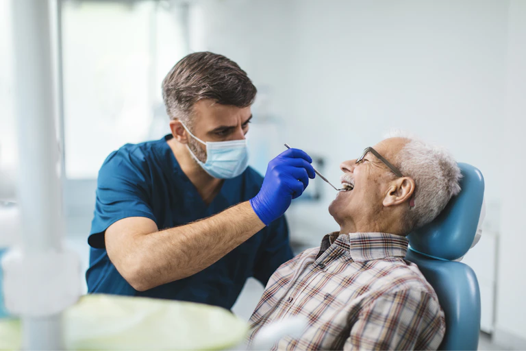 A man is examined by a younger male dentist.