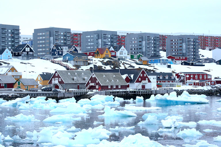 Casas y bloques de viviendas se asoman al mar, donde flotan bloques de hielo