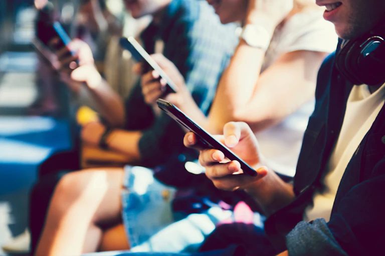 Des adolescents en train de consulter leurs téléphones portables.