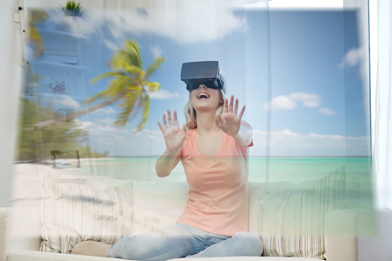 Femme avec un casque de réalité virtuelle devant une plage virtuelle.