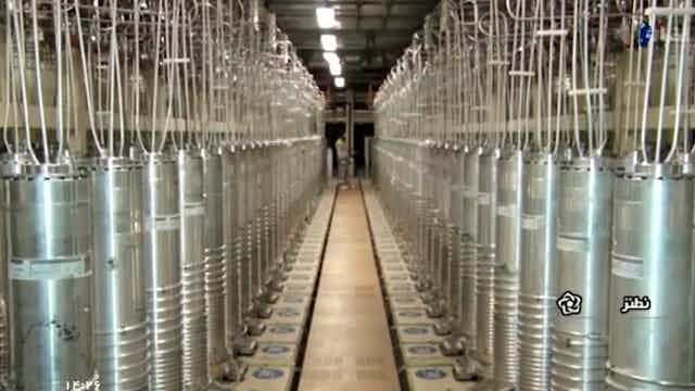 two parallel rows of vertical metal tubes with hoses attached to the tops