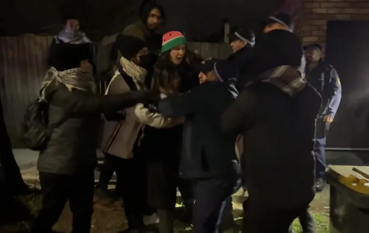 A protest crowd in a scuffle during a nighttime protest