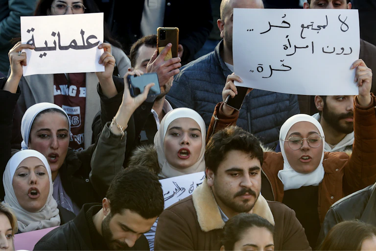 Syrian women chant slogans as they hold placards