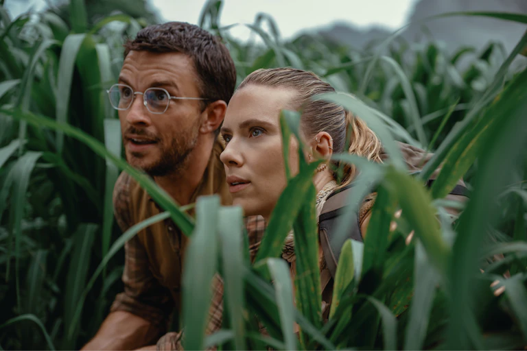 Jonathan Bailey and Scarlett Johansson in a field of tall grass.
