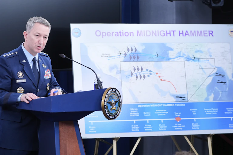 a man in a military uniform stands behind a podium next to a poster of a map