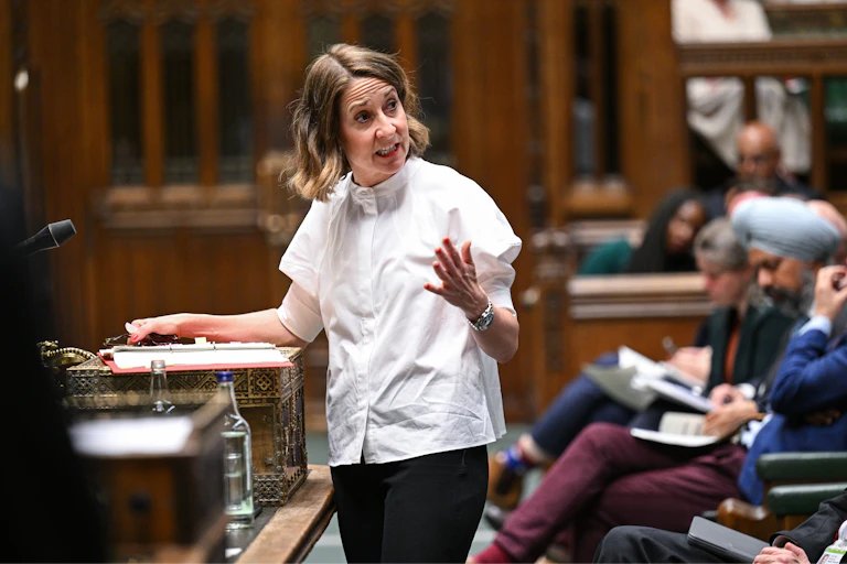 Liz Kendall in a white blouse, gesturing and speaking to MPs over her shoulder