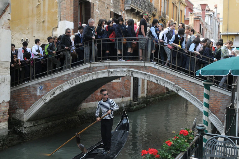 Tourists crowding on an old bridge in Venice, Italy