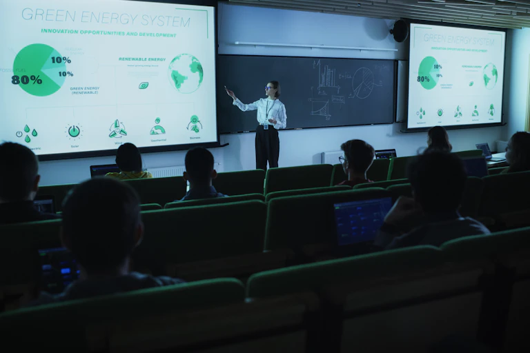 Clase en universidad con grandes pantallas donde se exponen conceptos medioambientales