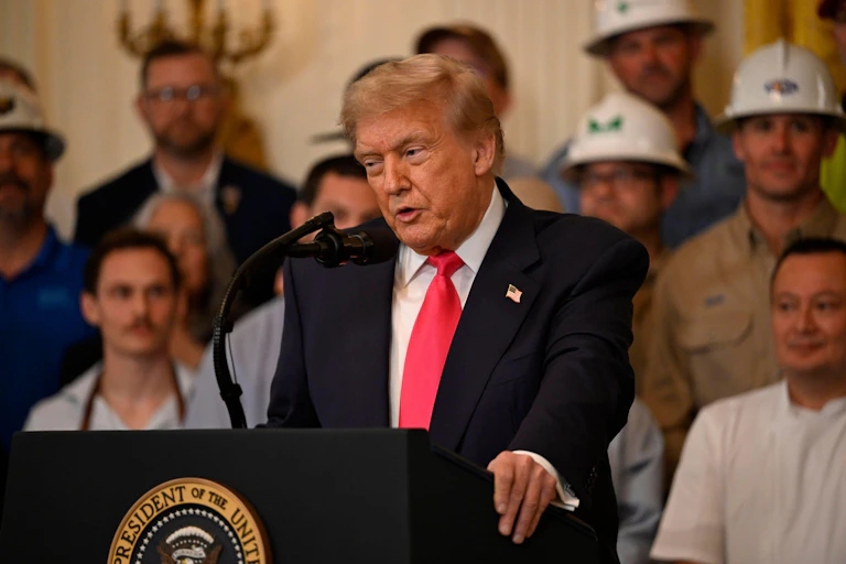 Donald Trump speaking at a podium surrounded by people at a 'big beautiful bill' event at the White House.