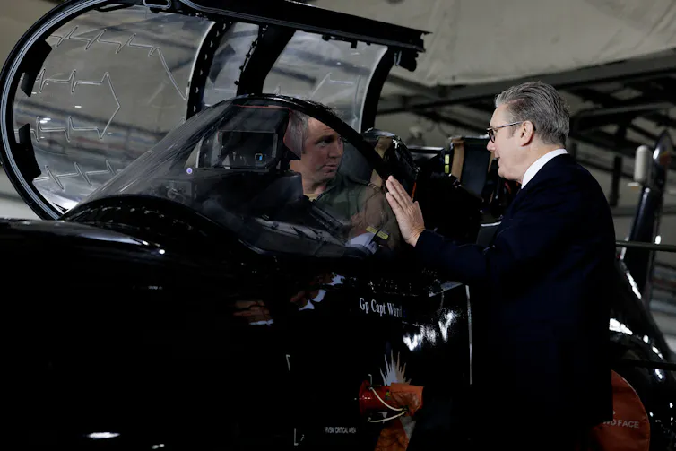 Keir Starmer talking to a pilot sitting in a fighter jet.