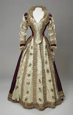 A 16th-century style dress in beige and maroon with a sweetheart neckline.
