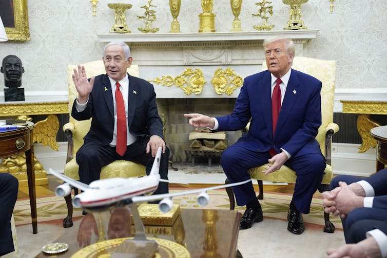 Israel's prime miinister Benjamin Netanyahu waves for the cameras as he sits with US president Donald Trump in the White House, April 2025.