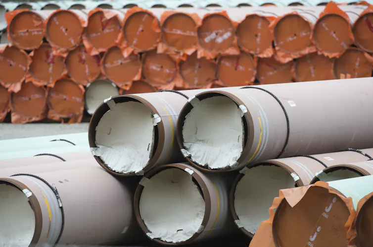 Large pipes stacked in tall piles