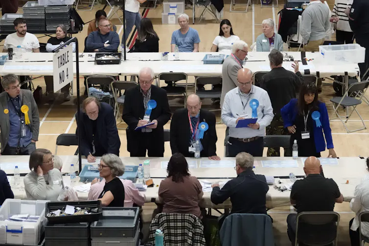 Election officials monitoring vote counting.