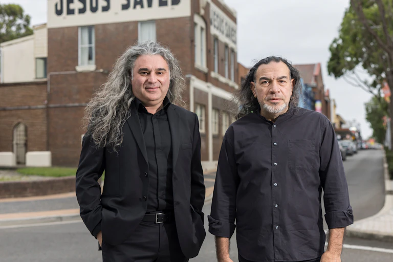 Portrait photo of two men in black.