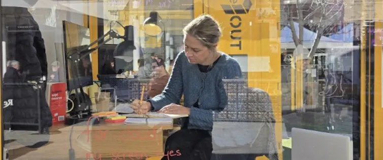 Woman writing behind glass window