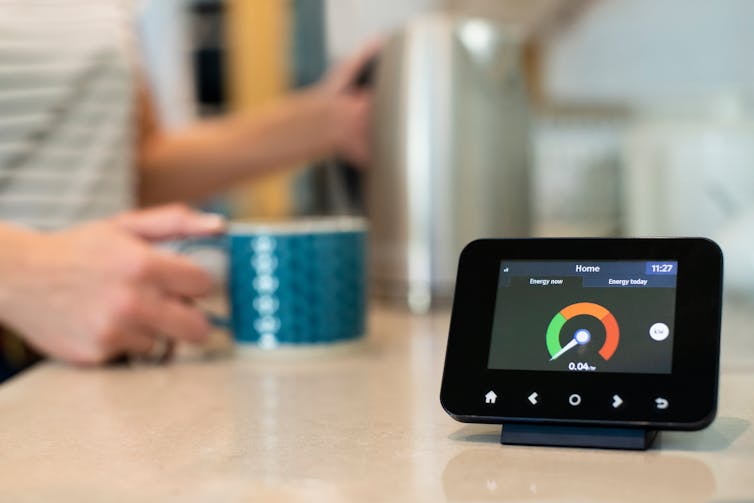 smart meter, woman boiling kettle in background