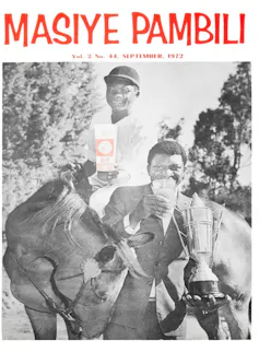 A younger African man sits on a horse in equestrian gear holding a carton offer while an older African man stands beside the horse holding a glass of beer and a trophy.