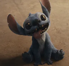 A dog-like character has his tongue out and teeth bared while smiling.