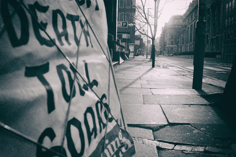 Black and White "Death Toll Soars" newspaper headline on an empty street