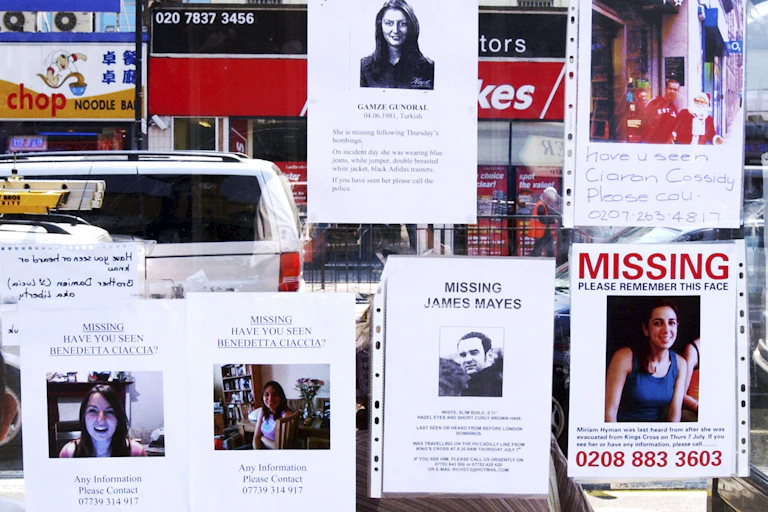 Several posters of missing persons on a window on a London street