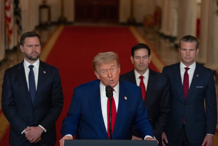 Donald Trump flanked by senior aides speaks at a podium in the White House, June 22 2025.