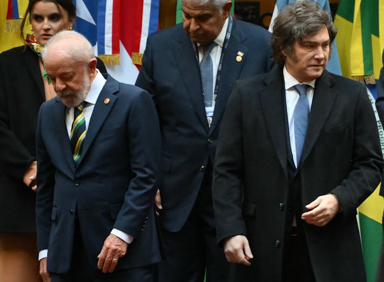 Two men in suits turn away from each other.