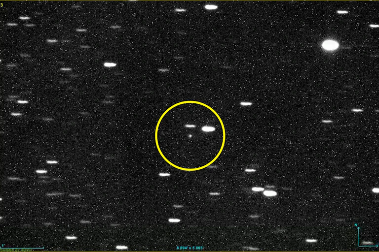 Telescope image showing a tiny object circled against a background of stars