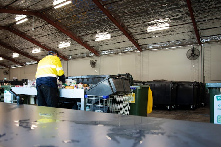 A man sorts recycling.