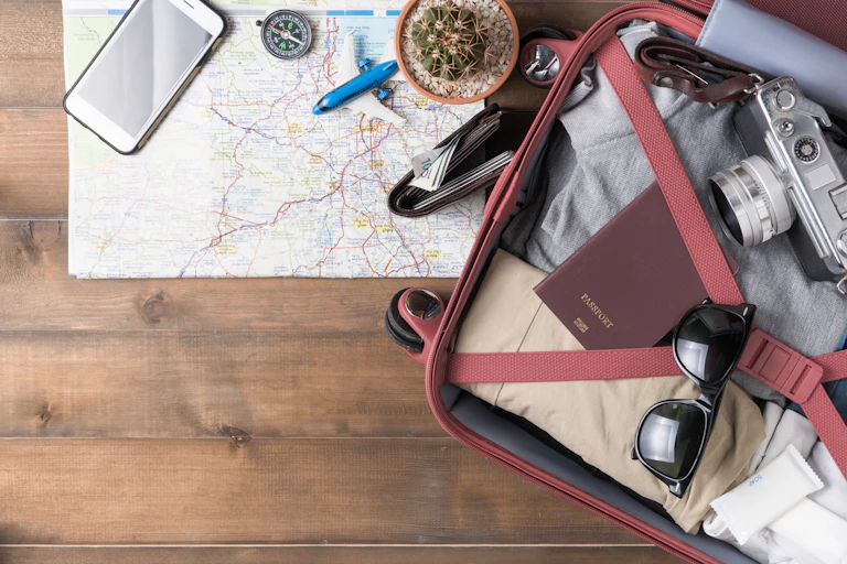 Bodegón de objetos relacionados con un viaje: maleta, mapa, cartera con dinero, pasaporte...