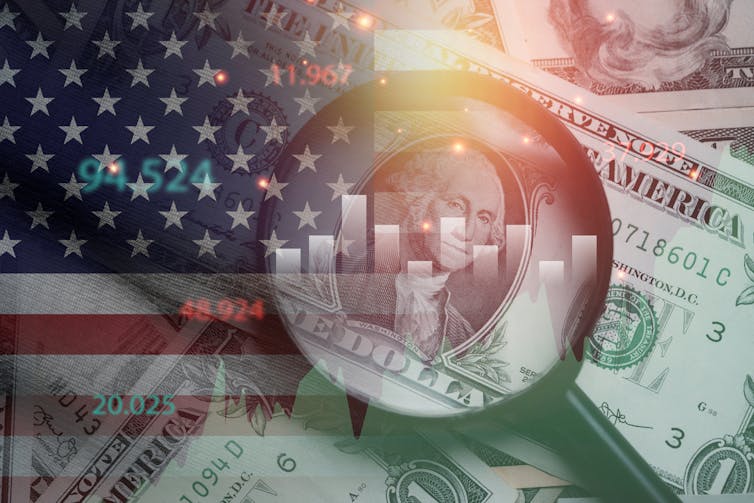 Magnifying glass on US dollar bill with US flag and financial chart graphics.