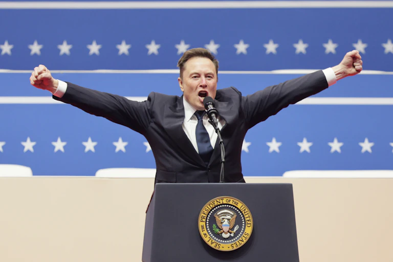 Elon Musk raises his arms in a victory pose while giving a speech on the US president's podium.