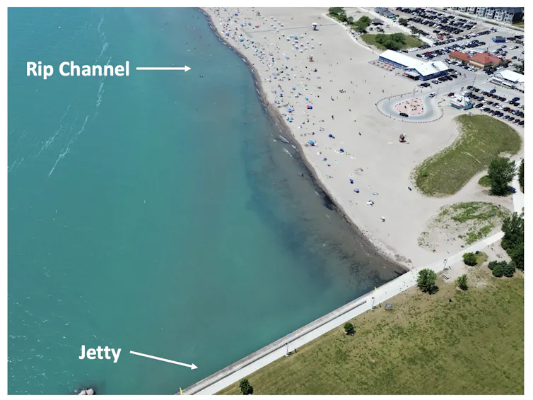 Aerial photo of a shoreline with a beach and jetty