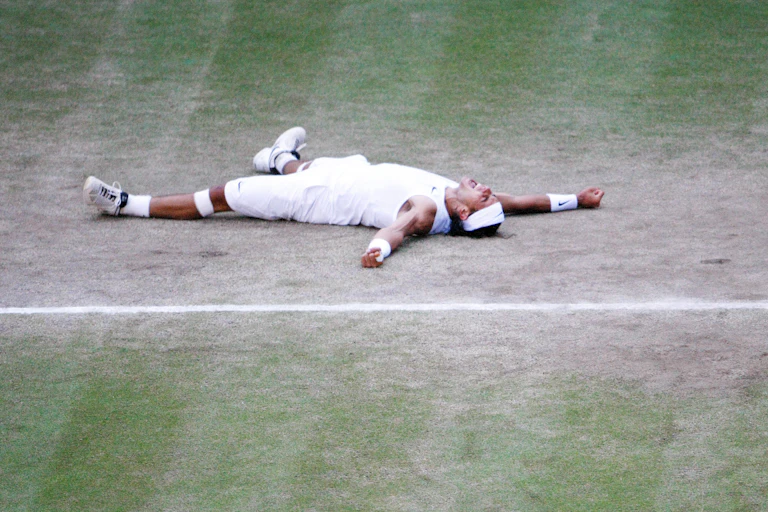 Rafael Nadal lying on the floor in his Wimbledon whites.