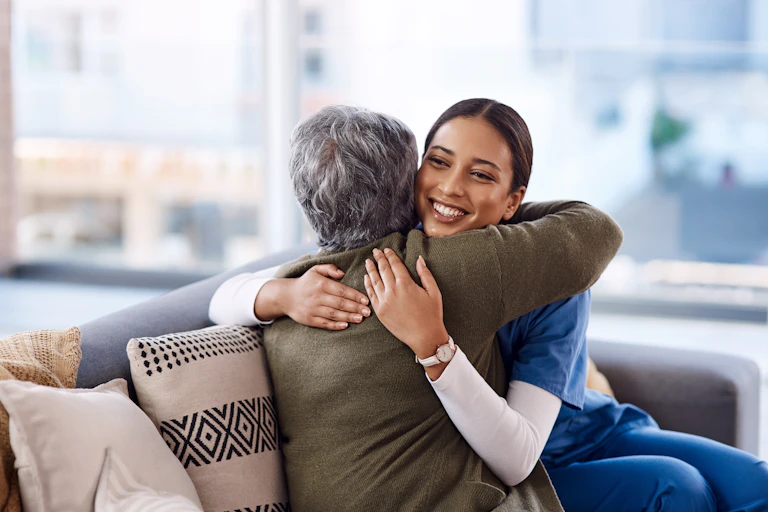 A younger woman hugging an older woman.