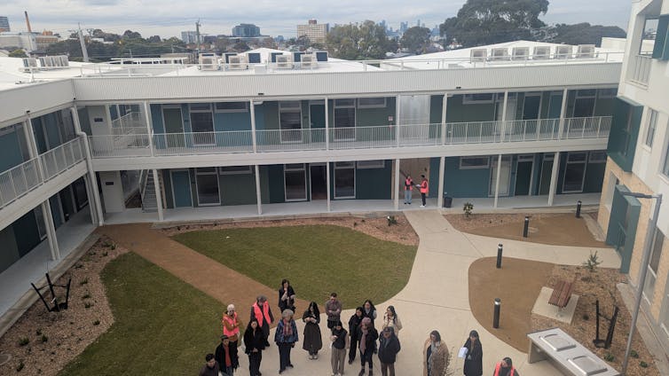 Several people standing in a housing courtyard
