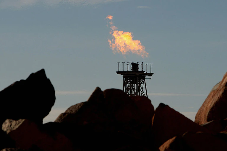 Gas flares from pipes at dusk.