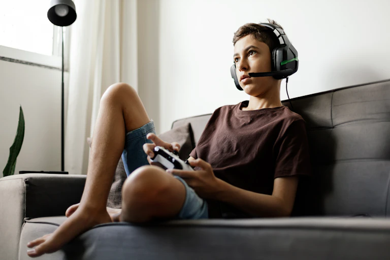 Teen boy on sofa playing video games