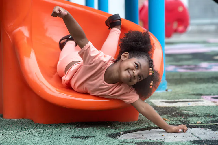 Happy girl going down slide