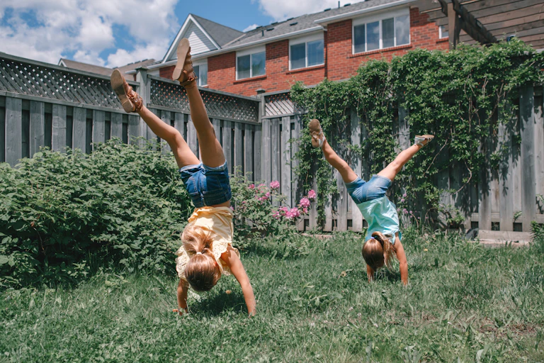 Girls doing handstands in back garden