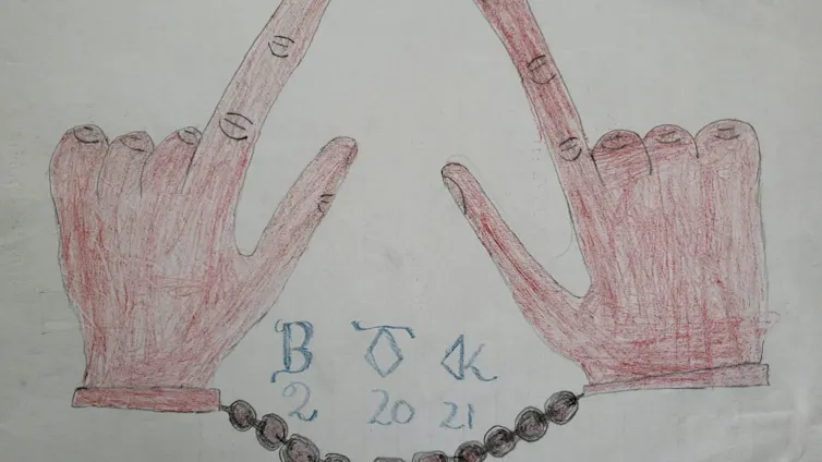 A crude drawing of two hands, a finger and thumb pointed upward on each, bound by chains and with the letters BTK with the numbers 2-20-21.