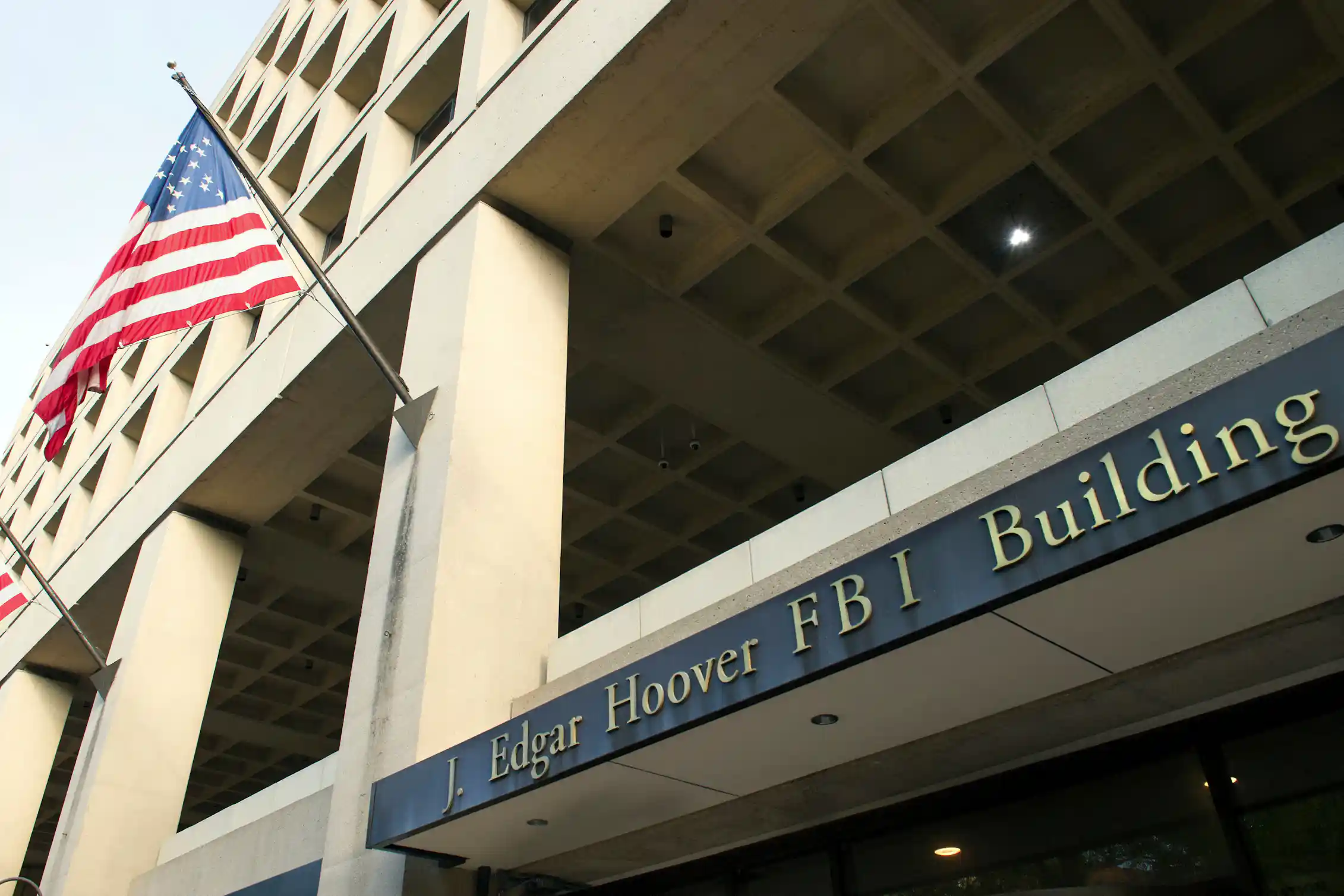 Exterior view of a federal building with an American flag flying on a mast.