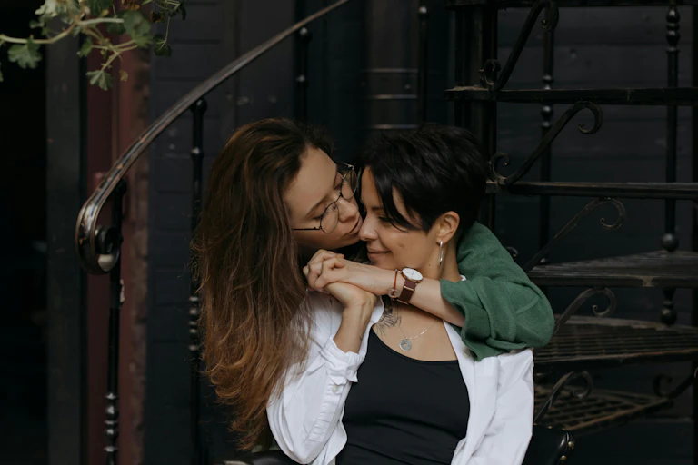 Two women, one with her arms around the other