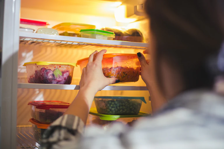 Person takes plastic container out of fridge