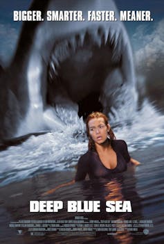 A shark mouth looms above a busty woman.